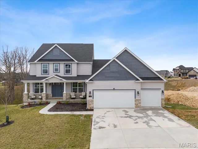 Craftsman-style house with stone siding, a porch, driveway, a front yard, and a garage