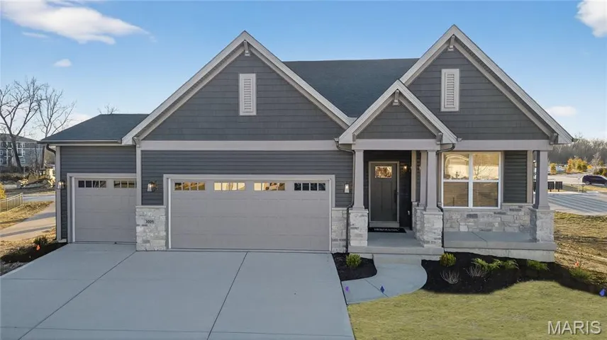 Craftsman inspired home featuring stone siding, concrete driveway, an attached garage, and a front yard