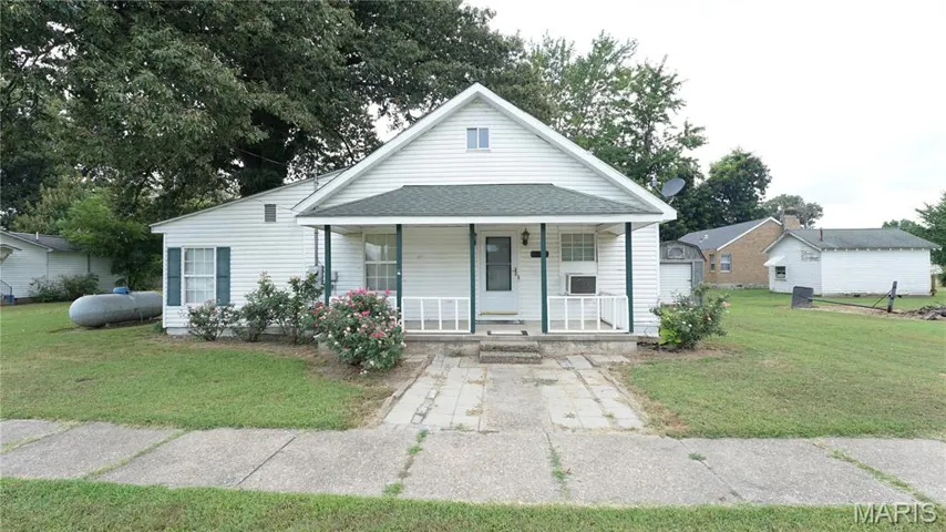 Bungalow-style home with covered porch, a front yard, and a shingled roof