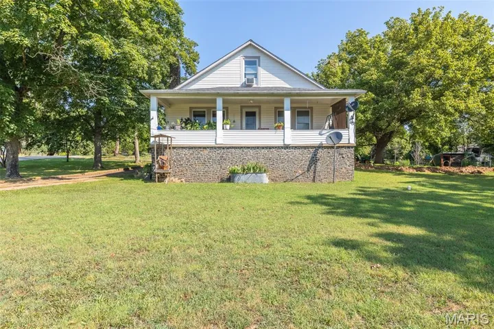 View of front facade with a front yard and covered porch