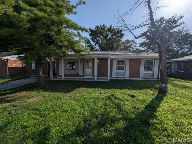 View of front of property featuring a porch, a front yard, and brick siding