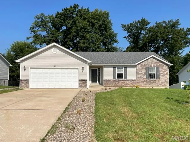 Single story home with a garage, brick siding, driveway, a front lawn, and a shingled roof