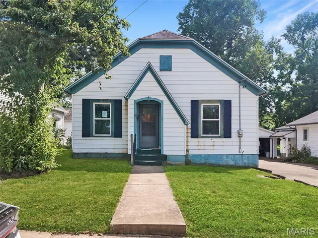 Bungalow-style home with a front lawn and entry steps