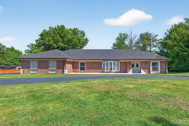 Single story home featuring a front lawn, brick siding, and a shingled roof
