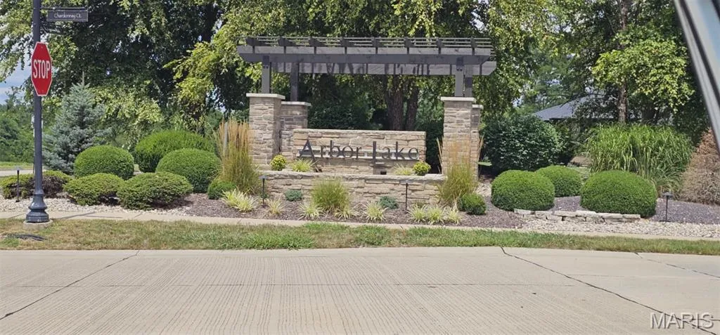 Community sign with view of wooded area