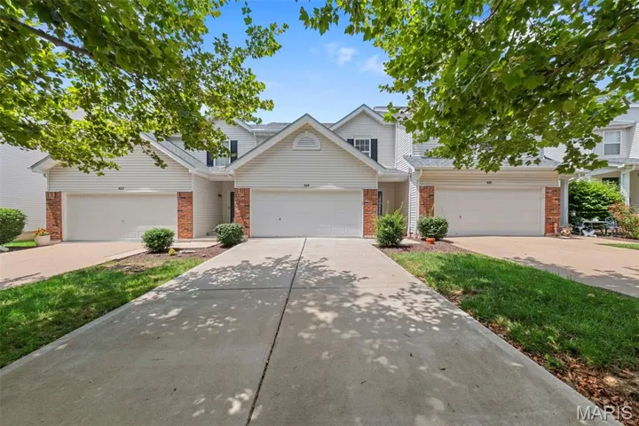 Traditional-style house featuring concrete driveway and brick siding
