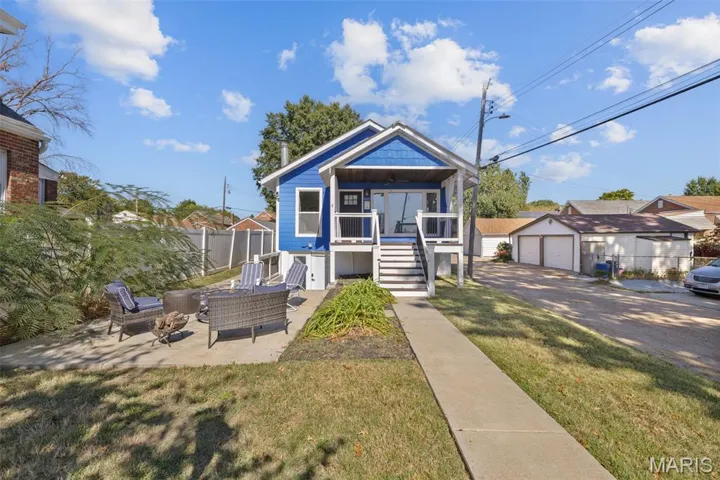 Bungalow-style house featuring stairway, a detached garage, outdoor lounge area, a patio area, and a porch