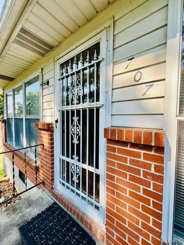 Entrance to property featuring covered porch