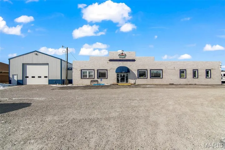 View of front of property featuring brick siding and a garage