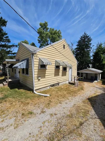 View of side of home with a yard