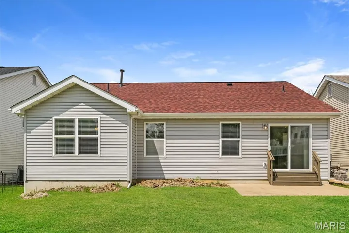 Back of house with a shingled roof, a yard, a patio area, and entry steps