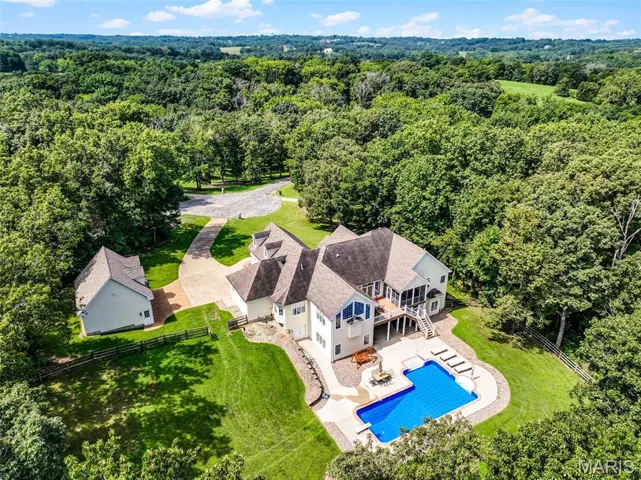 View from above of property with a forest and a pool area