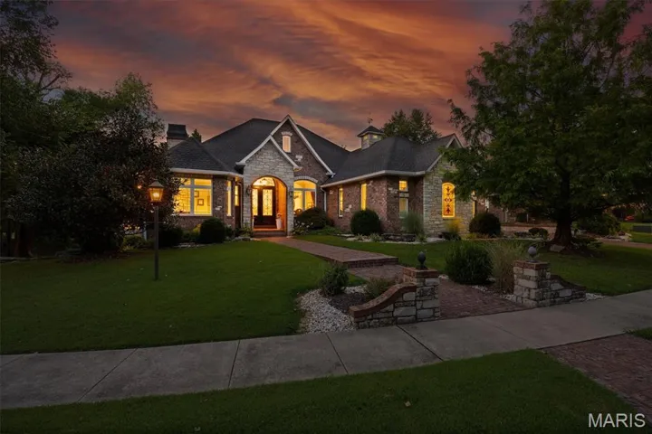French country style house featuring stone siding, a yard, and a chimney