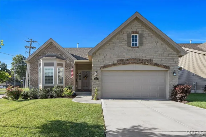 View of front facade featuring driveway, a front lawn, a garage, and roof with shingles