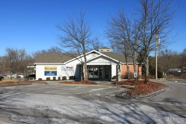 View of building exterior with uncovered parking