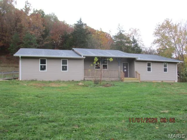 Single story home with covered porch and a front yard