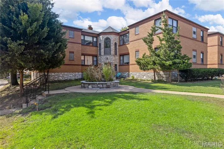 View of property's community featuring a lawn and a patio area