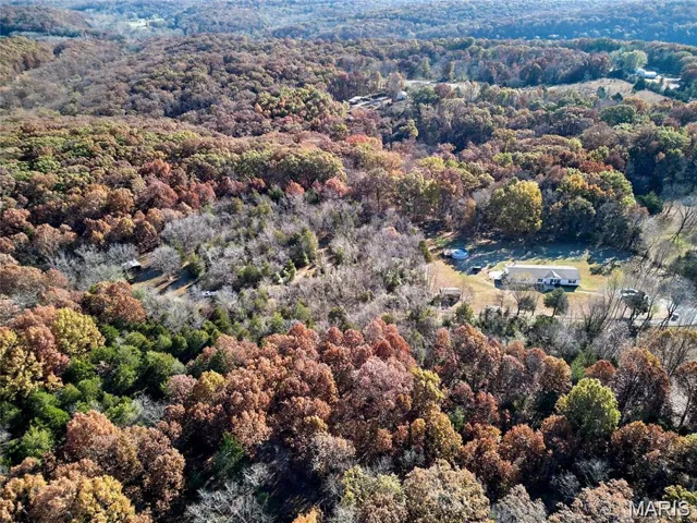 Aerial view of property's location featuring a heavily wooded area