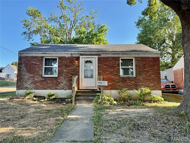 Bungalow with brick siding, roof with shingles, and entry steps
