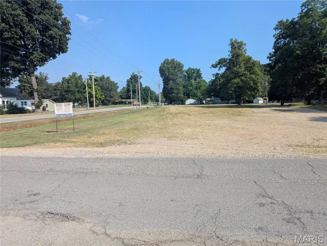 View of asphalt road with view of wooded area