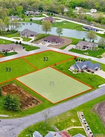 Aerial view of residential area featuring a large body of water and property parcel outlined