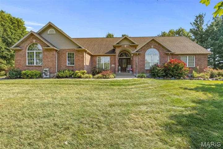 Ranch-style home featuring brick siding, a shingled roof, and a front yard