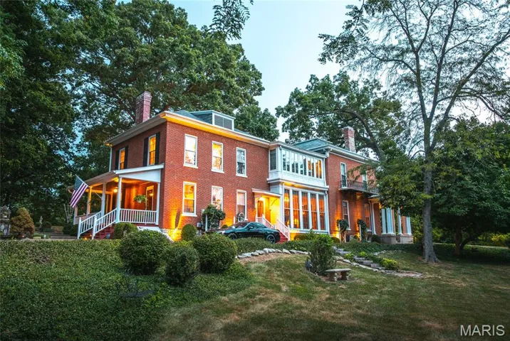 View of front of house with a chimney, brick siding, and a front yard