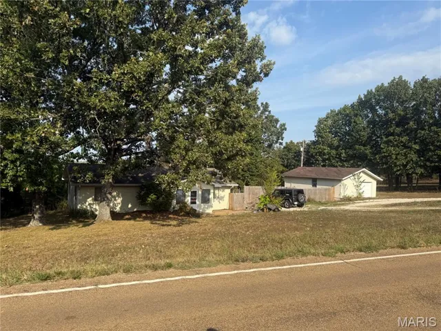 View of front of house featuring a front lawn and a detached garage