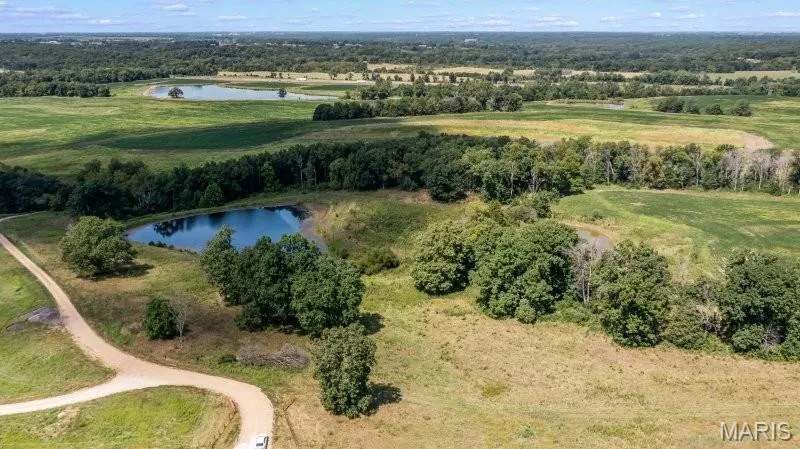 Aerial view of property and surrounding area featuring a nearby body of water