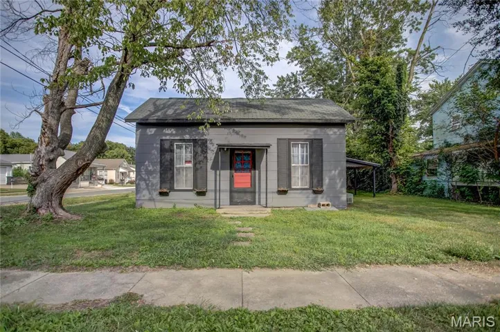 View of front of property with a front yard and a shingled roof