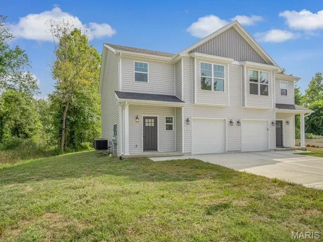 View of front of home featuring driveway, a front lawn, and a garage