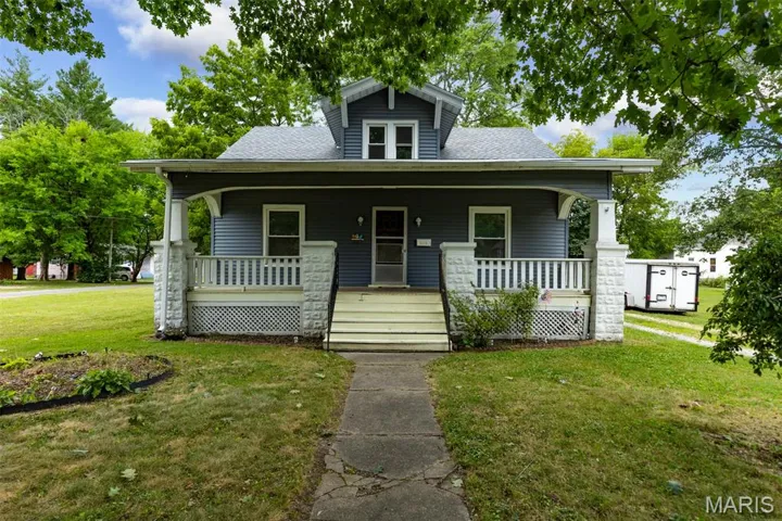Bungalow-style house featuring a front lawn, covered porch, and a shingled roof