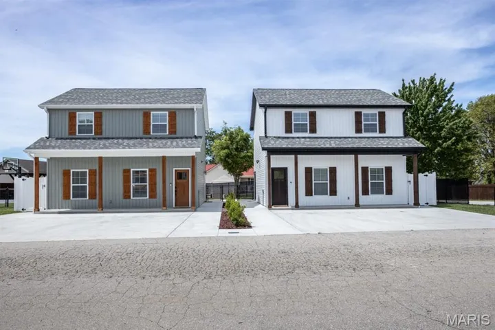 Modern farmhouse with roof with shingles and a porch