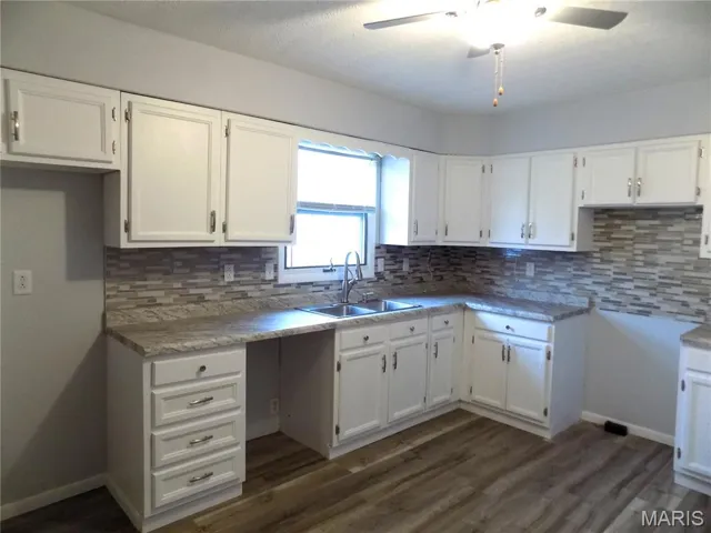 Kitchen featuring white cabinetry, tasteful backsplash, dark wood finished floors, and ceiling fan