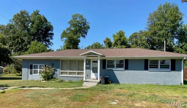 Single story home with brick siding, a front lawn, and crawl space