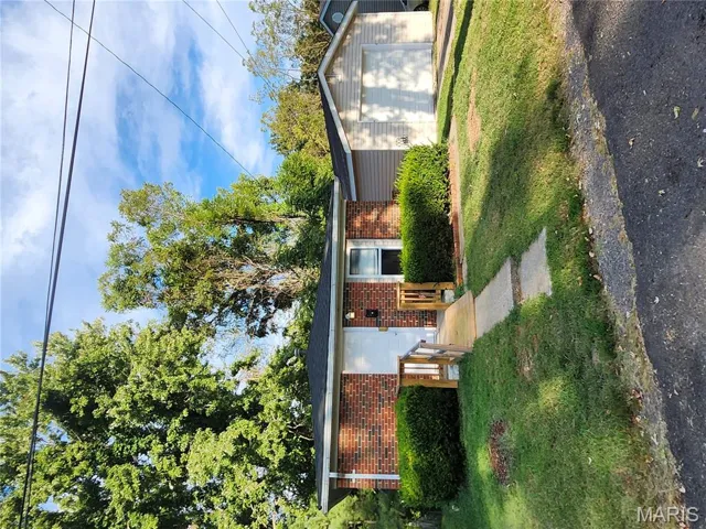 Single story home with an outbuilding, a garage, brick siding, and a front yard
