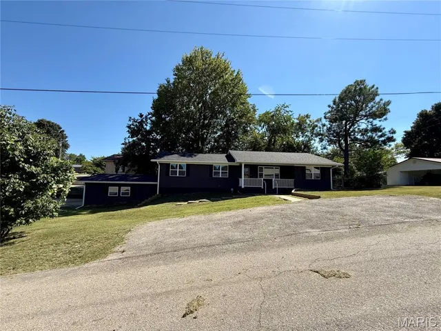 Ranch-style house featuring a front yard and covered porch