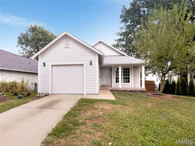 Single story home featuring a porch, driveway, an attached garage, and roof with shingles