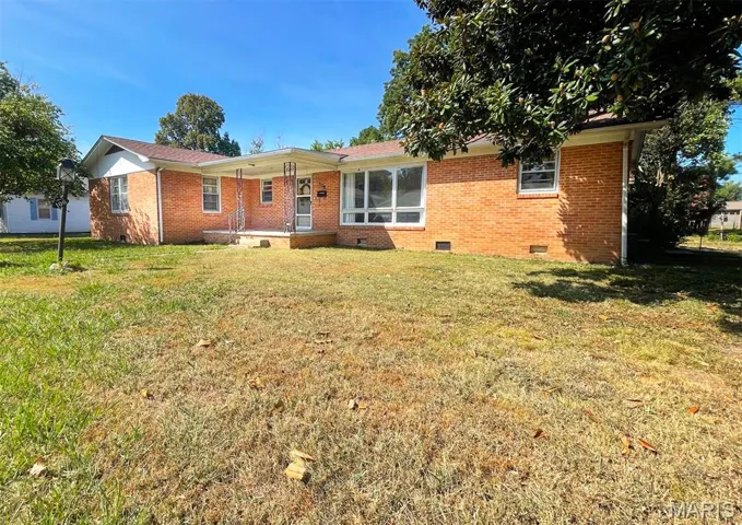 Back of property featuring crawl space, a lawn, and brick siding