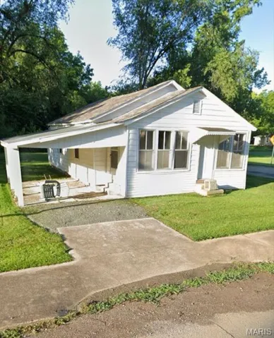 Back of house featuring a lawn