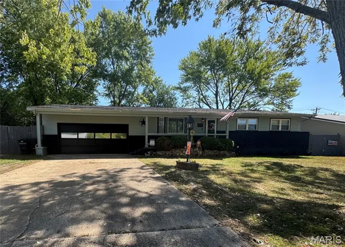 Single story home with concrete driveway and an attached garage