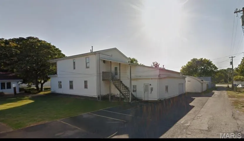 View of front facade featuring a front lawn and uncovered parking