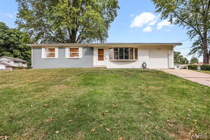 Ranch-style house with a front lawn, a garage, and driveway