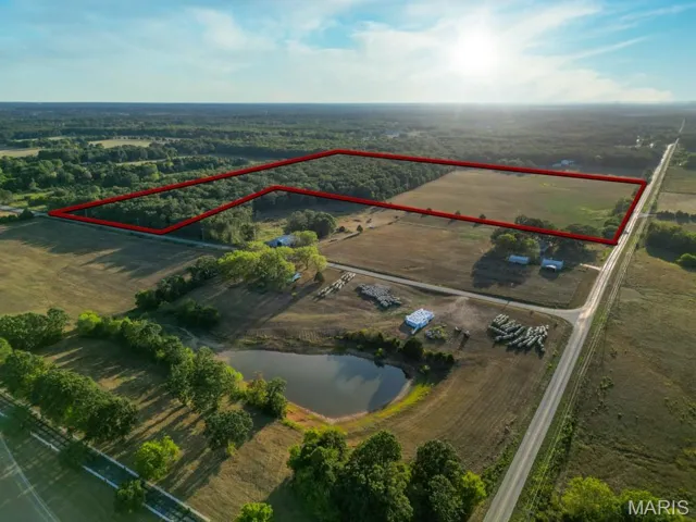 Aerial view of sparsely populated area featuring property boundaries highlighted and a large body of water