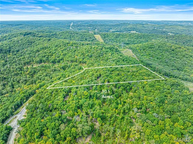 Aerial overview of property's location featuring property boundaries highlighted and a heavily wooded area