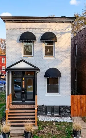 Doorway to property featuring brick siding