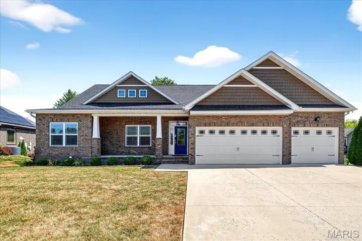 Craftsman inspired home with a porch, concrete driveway, a front yard, and brick siding