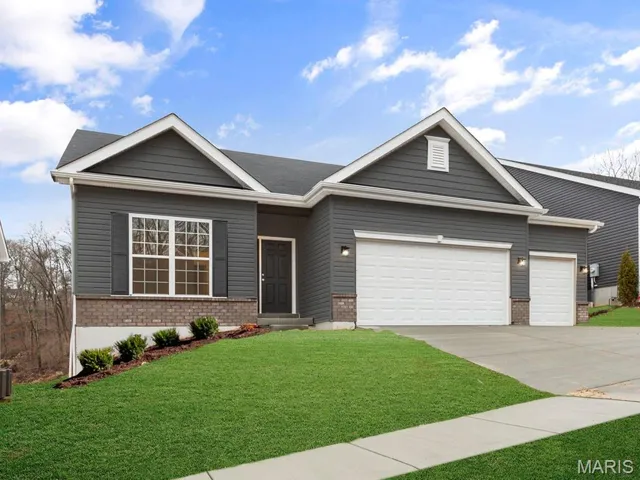 Single story home with brick siding, a garage, driveway, and a front lawn
