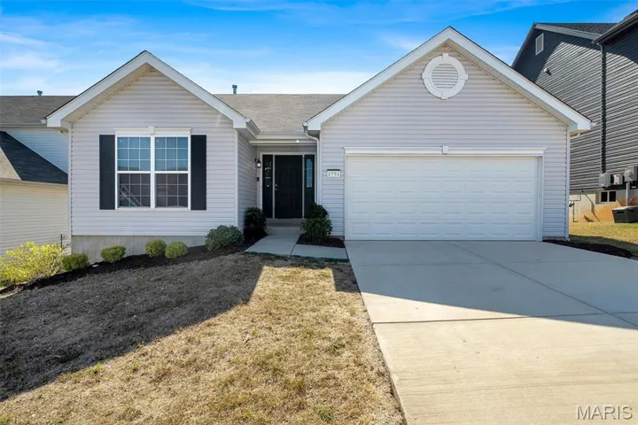 Ranch-style house featuring concrete driveway, a garage, a front yard, and a shingled roof