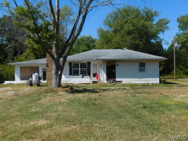 Ranch-style house featuring a garage and a front yard